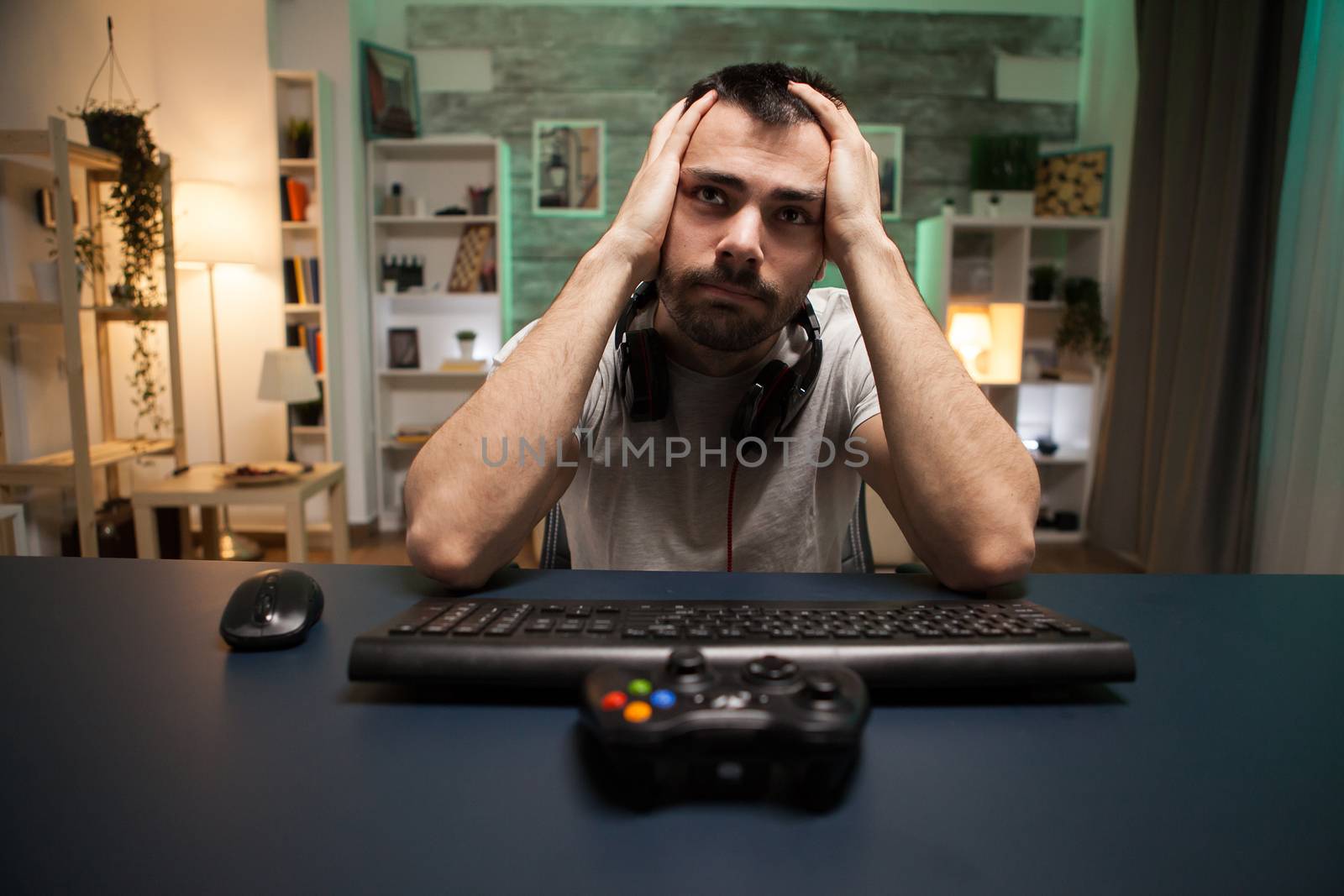 Pov of devastated professional shooter gamer after a big game over on online competition using wireless joystick.