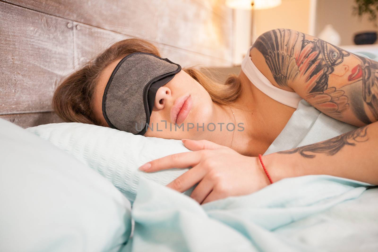 Caucasian beautiful woman sleeps with eye cover mask by DCStudio