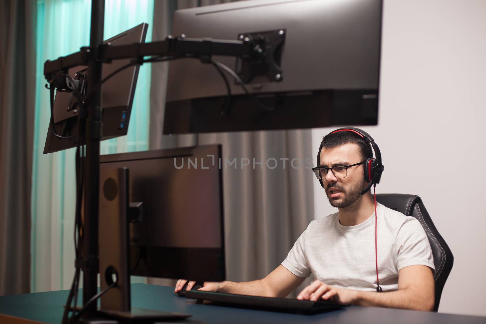 Man talking with others players using headphones with microphone while playing shooter game on stream.