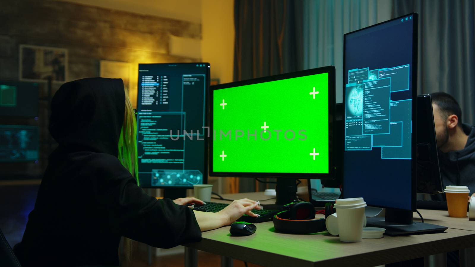 Hacker girl wearing a black hoodie in front of computer by DCStudio