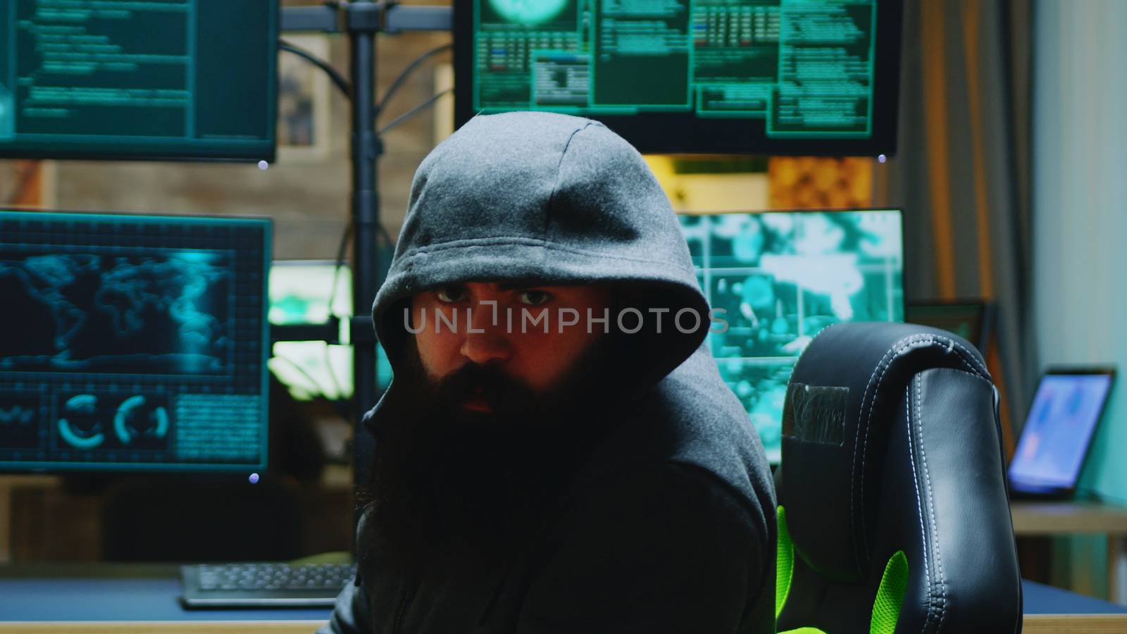 Dangerous hacker wearing a hoodies and looking into the camera. Cyber criminal.