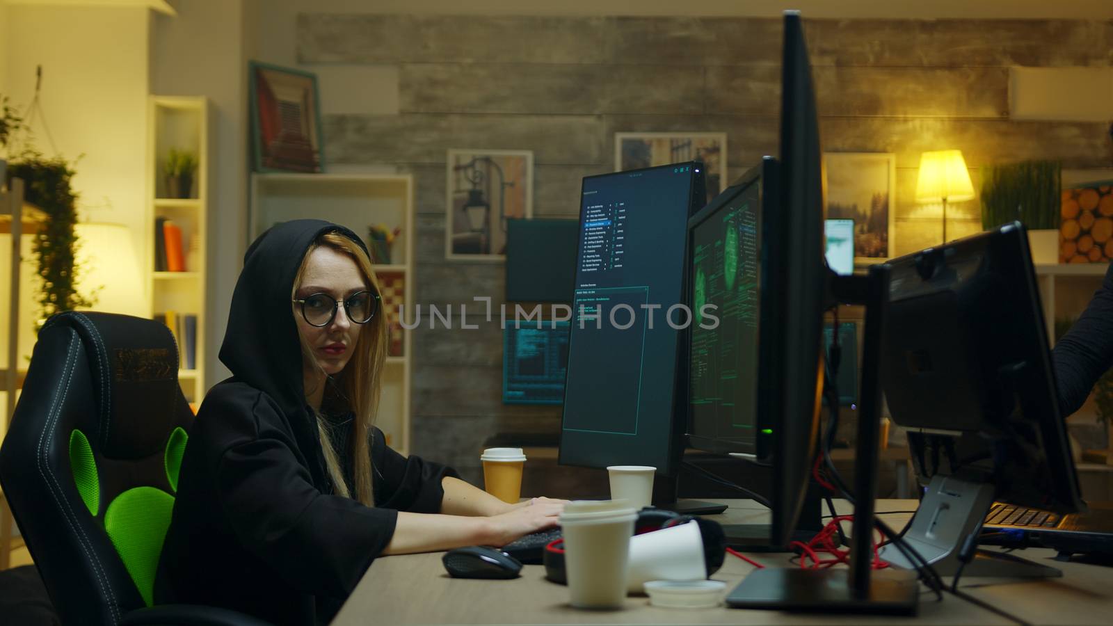 Hacker girl looking into the camera while stealing people identity using a malicious virus.