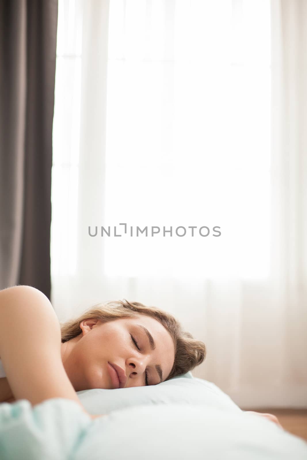 Young beautiful woman sleeping in her bed by DCStudio