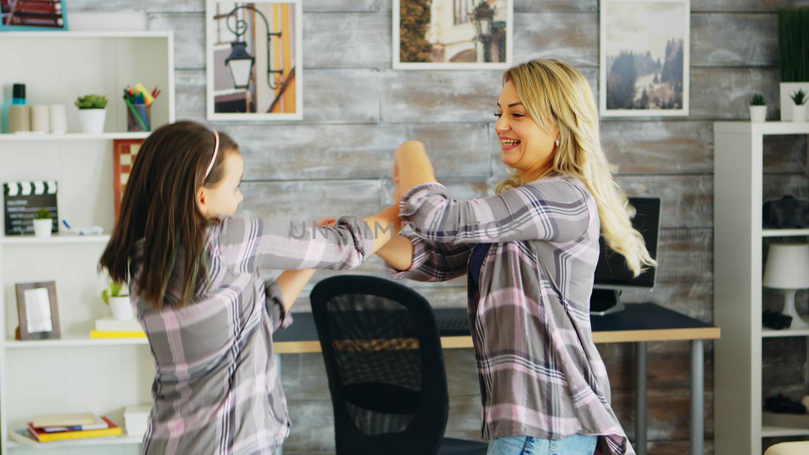 Happy mother and daughter dancing together by DCStudio