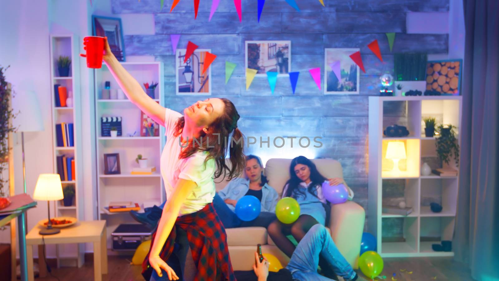 Care free young woman dancing with a cup of beer by DCStudio