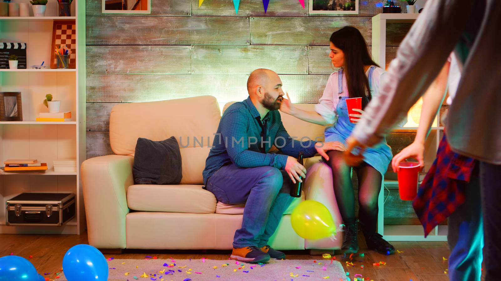 Beautiful young woman slaps young man at his friends party by DCStudio