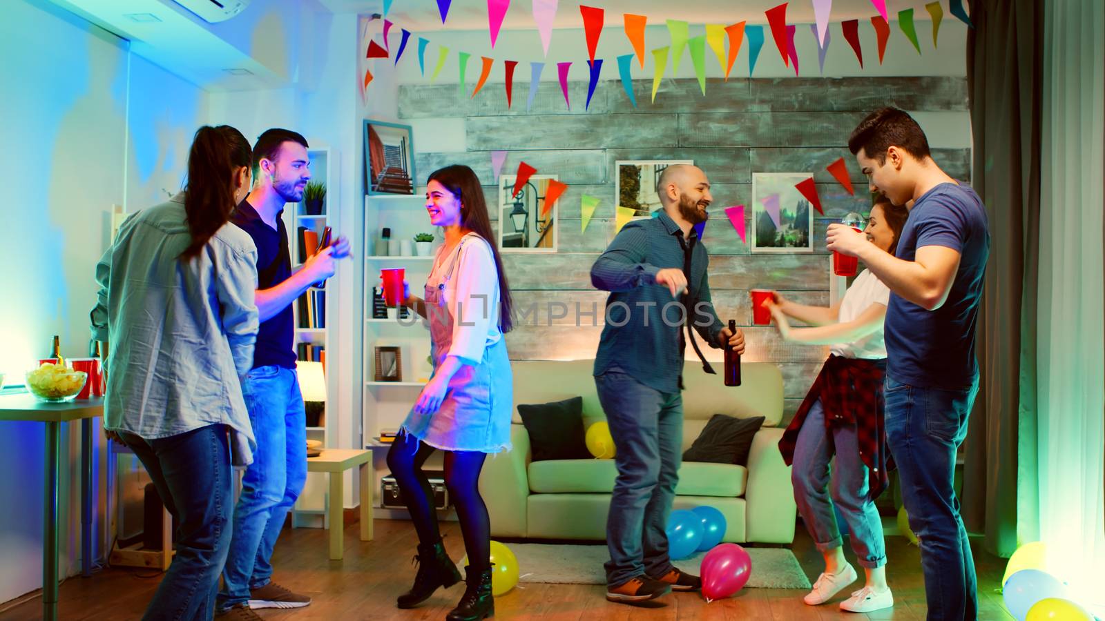 Group of young people dancing together at a party by DCStudio