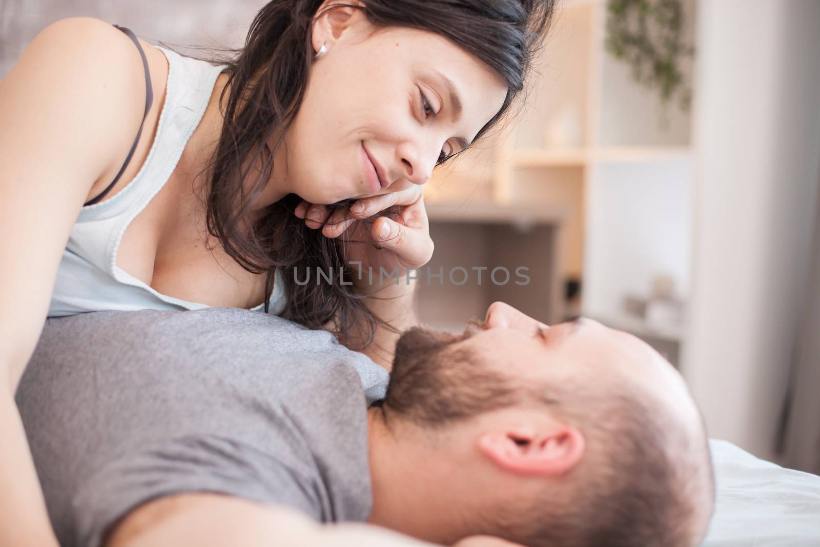 Caucasian couple laying in bed together by DCStudio