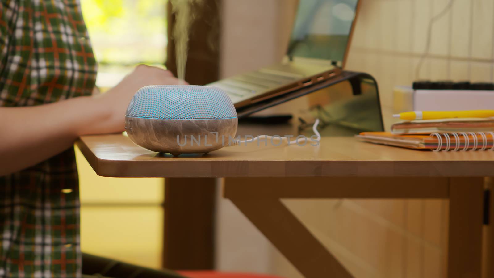 Zoom in shot aromatherapy diffuser working while freelancer woman works from the kitchen