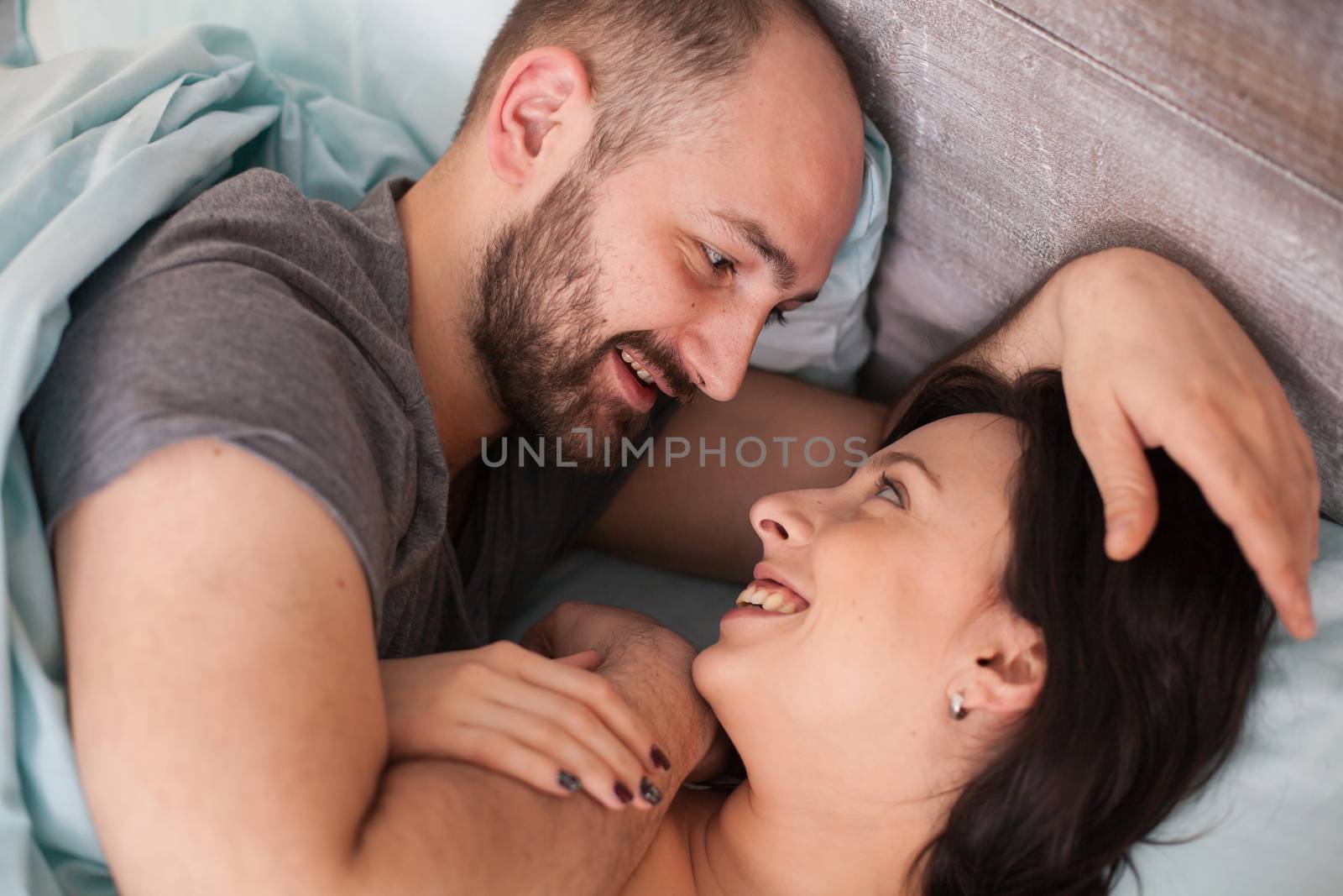 Beautiful loving couple in the morning wearing pajamas. Wife smiling.