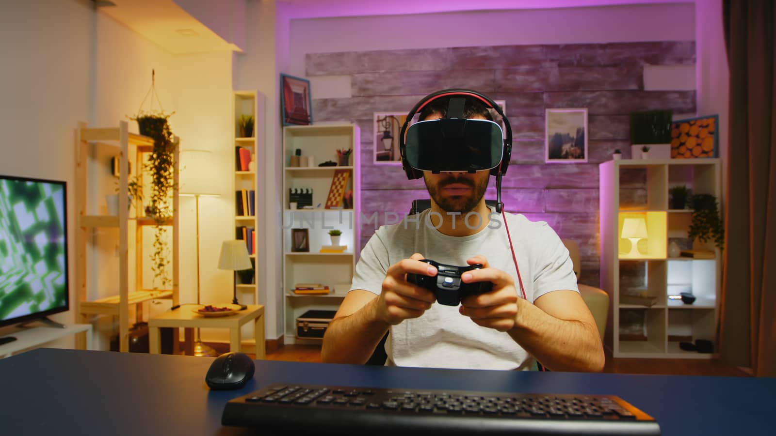 Pov of young man playing online games with virtual reality headset and wireless controller