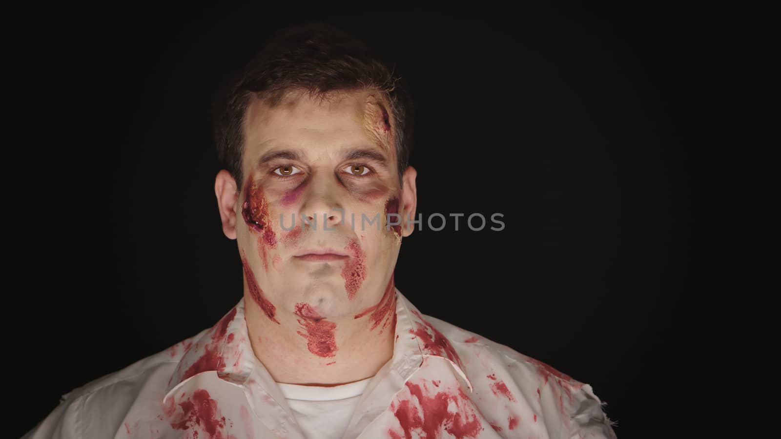 Portrait of caucasian man with make for halloween dressed up like a zombie.