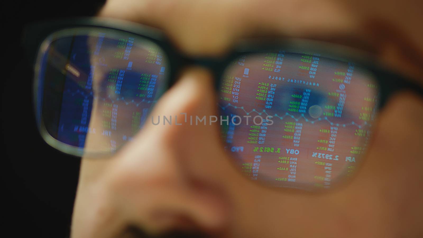 Close up reflection of stock market graphs in broker glasses by DCStudio