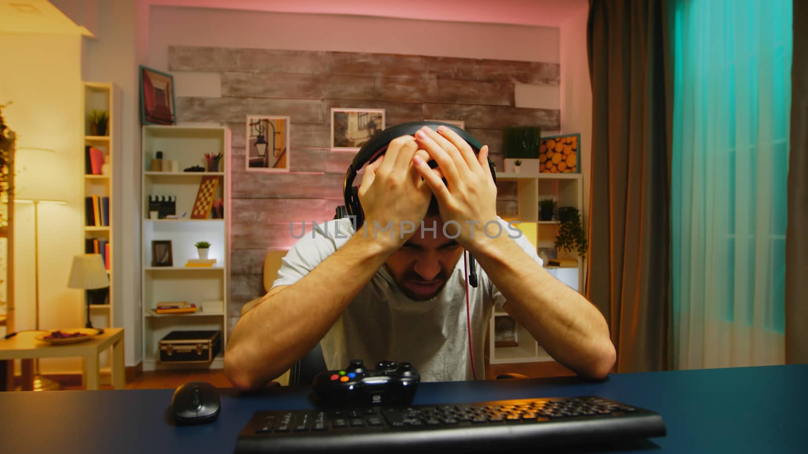 Pov young man talking with other players online games with wireless controller.