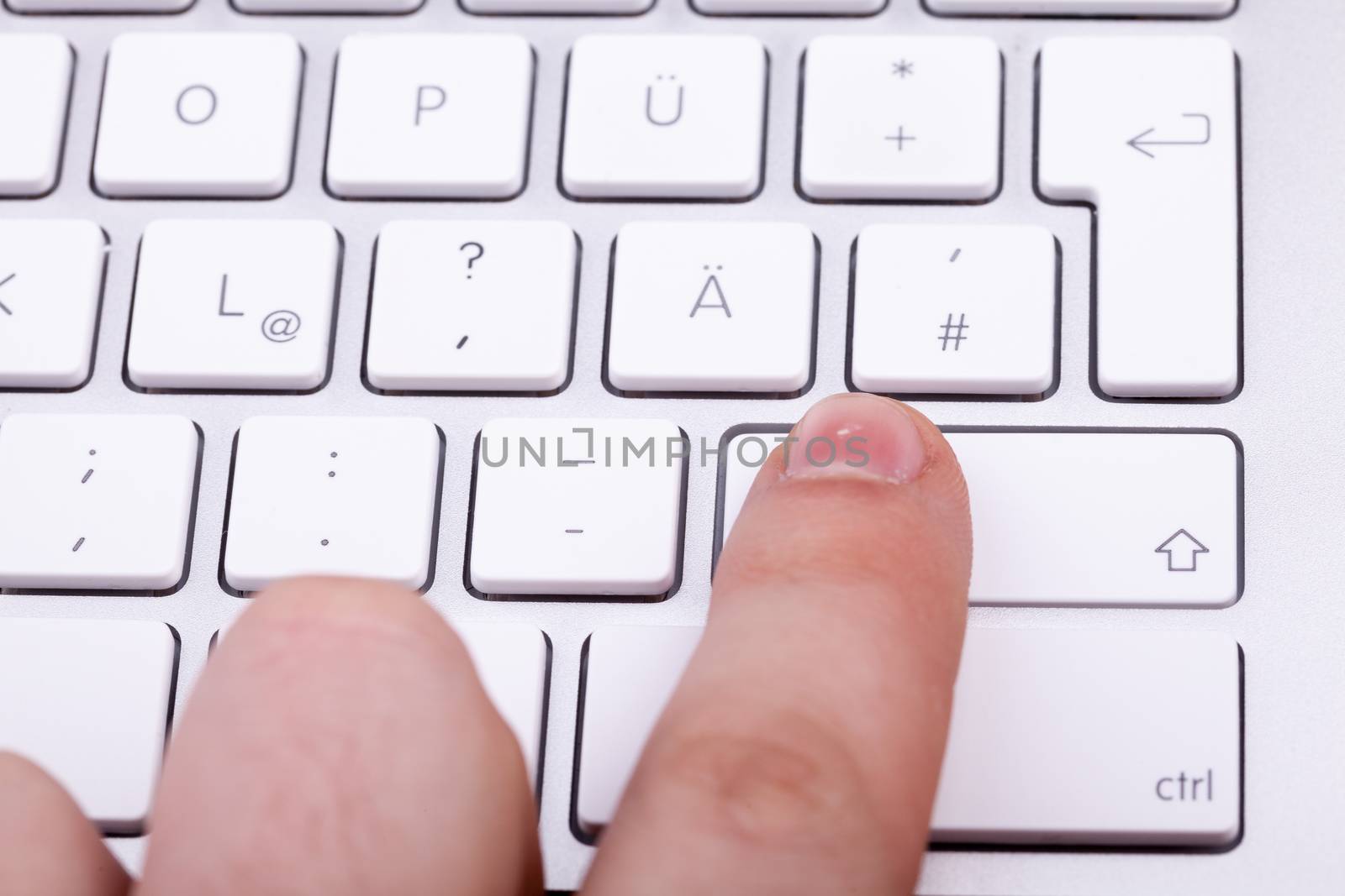 Finger pressing on keyboard key in close up