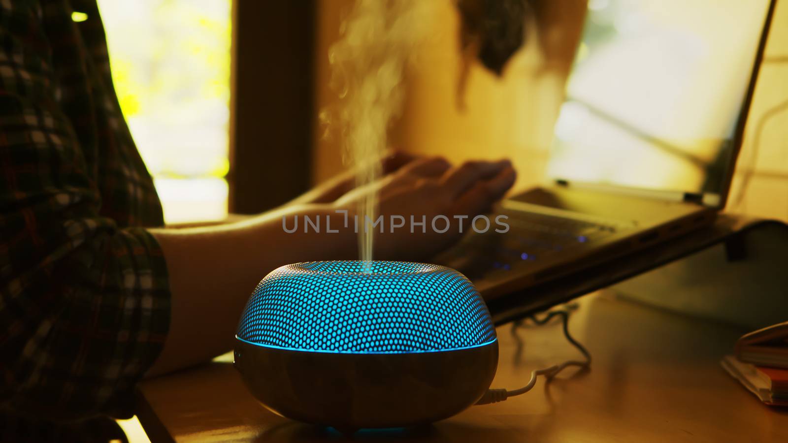 Silhouette of blue led essential oil diffuser steaming by DCStudio