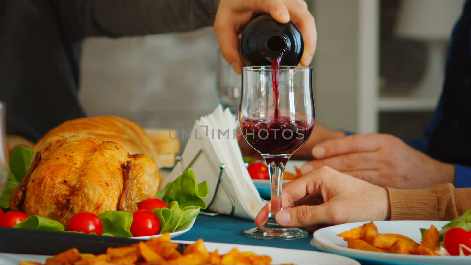 Close up of young man pouring red wine by DCStudio