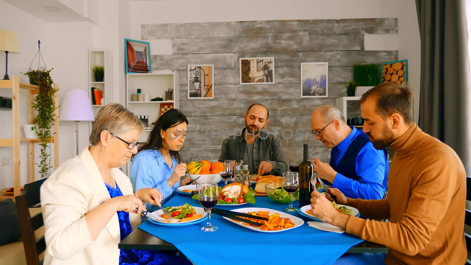 Zoom out shot of family enjoying delicious meal at dinner.