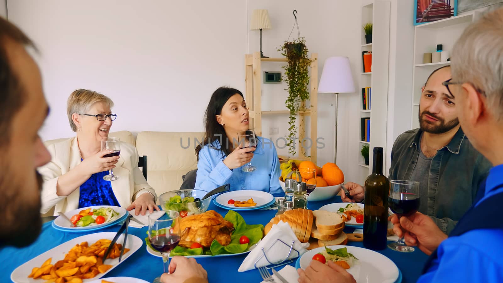 Young caucasian woman and her mother drinking wine at family dinner.