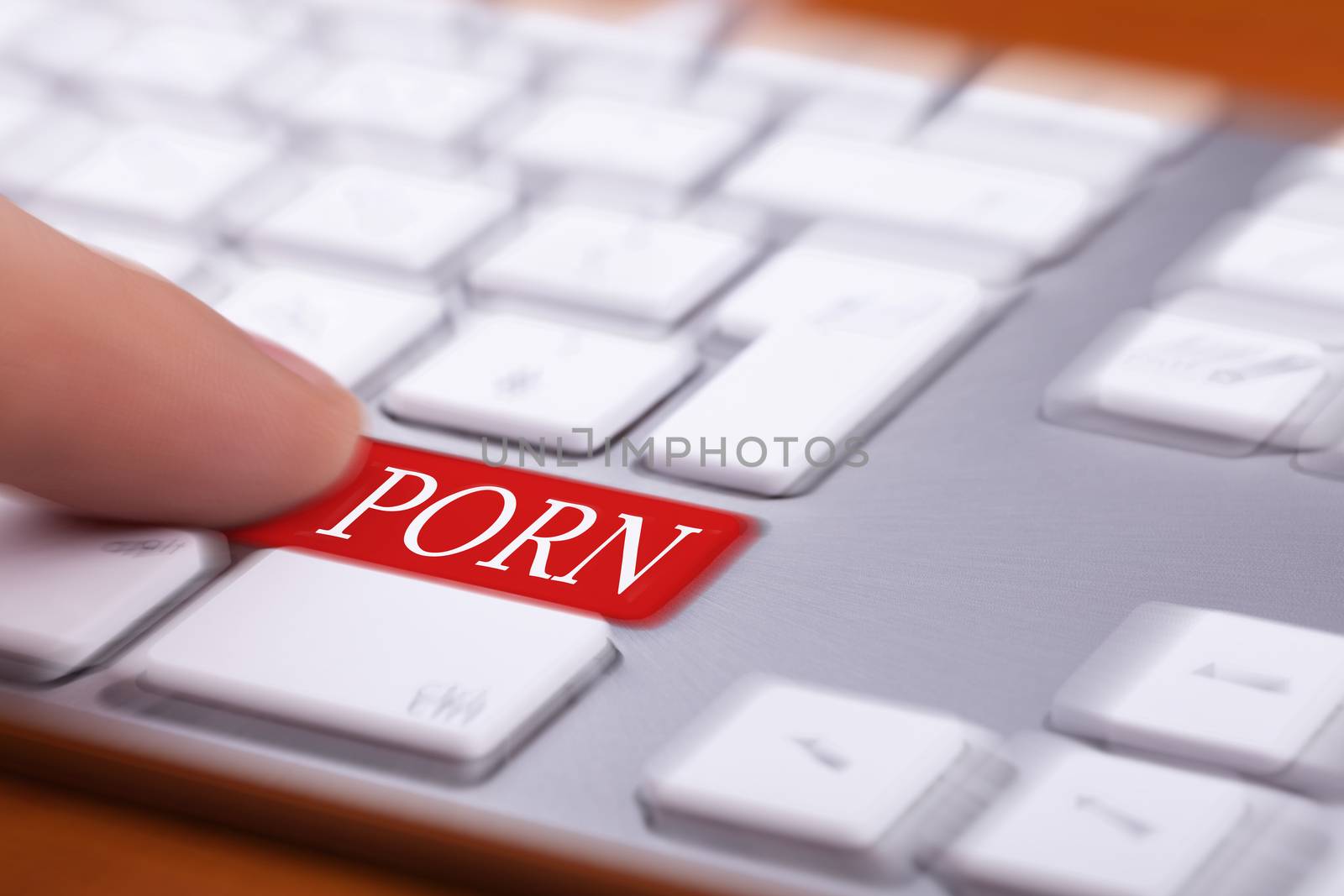 Finger pressing on red button with porn word on it and blurred background. Sex and xxx sites. Adult content only