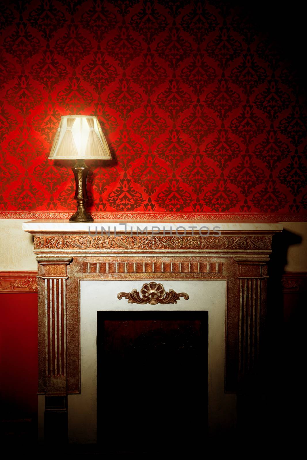 Beautiful old lamp on fireplace in red vintage room