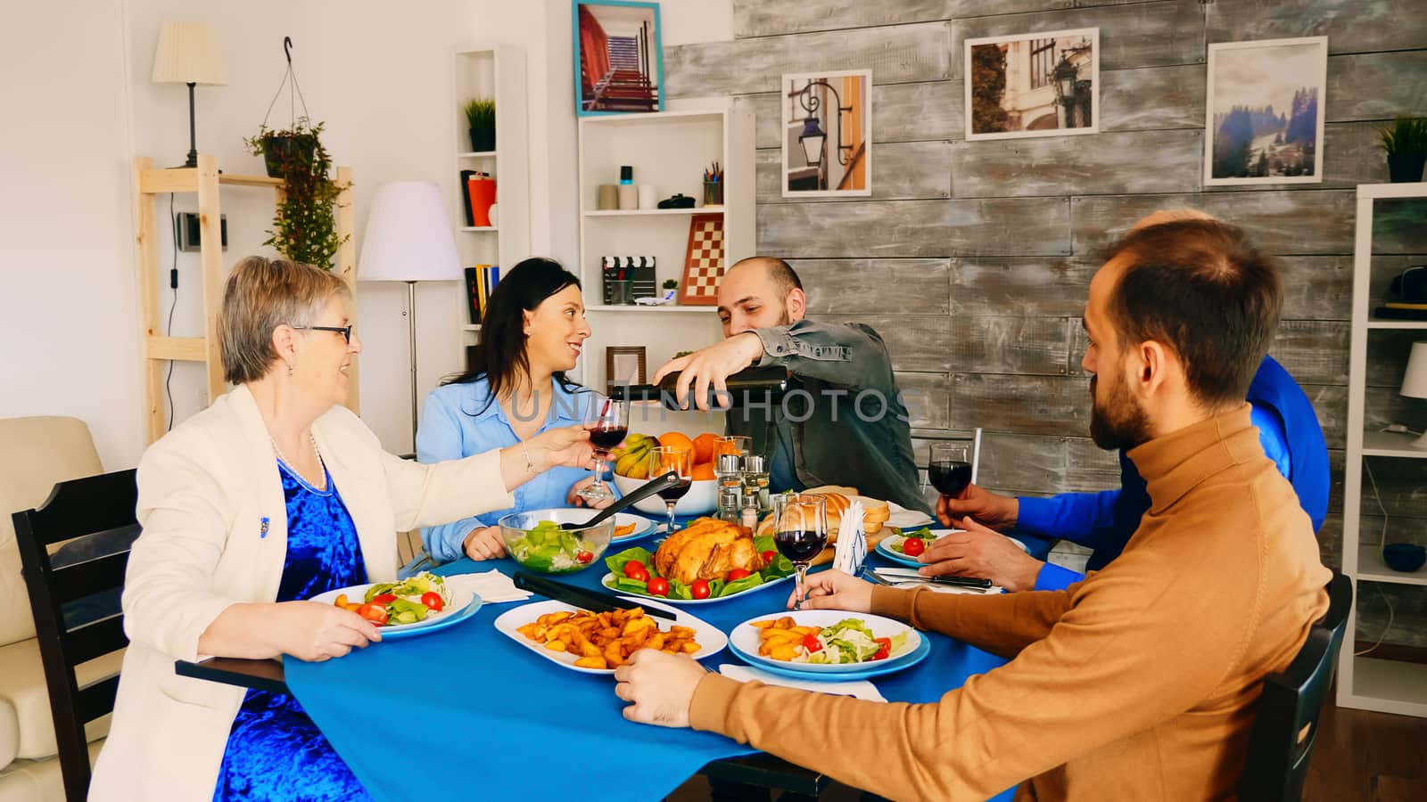 Young man pouring red wine by DCStudio