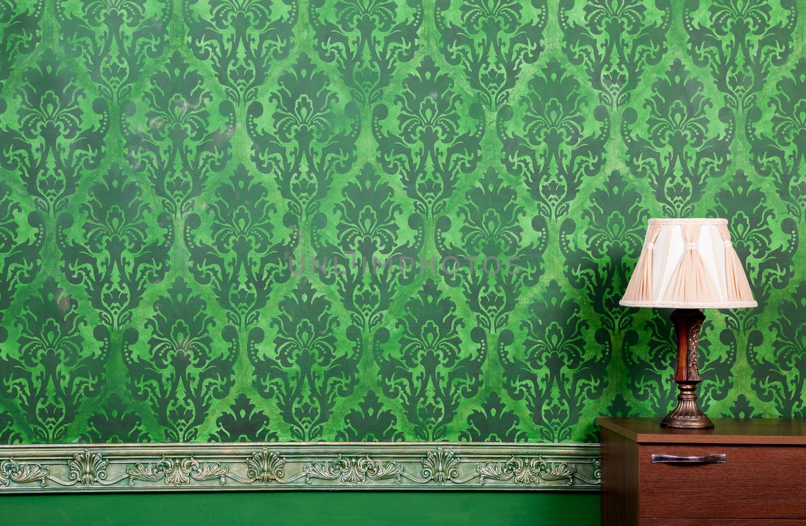 Lamp in vintage green interior with rococo pattern wall