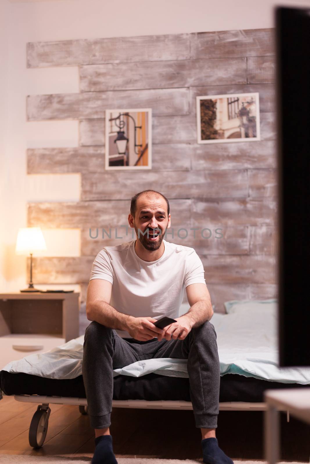 Young man enjoying his time in front of tv at night.