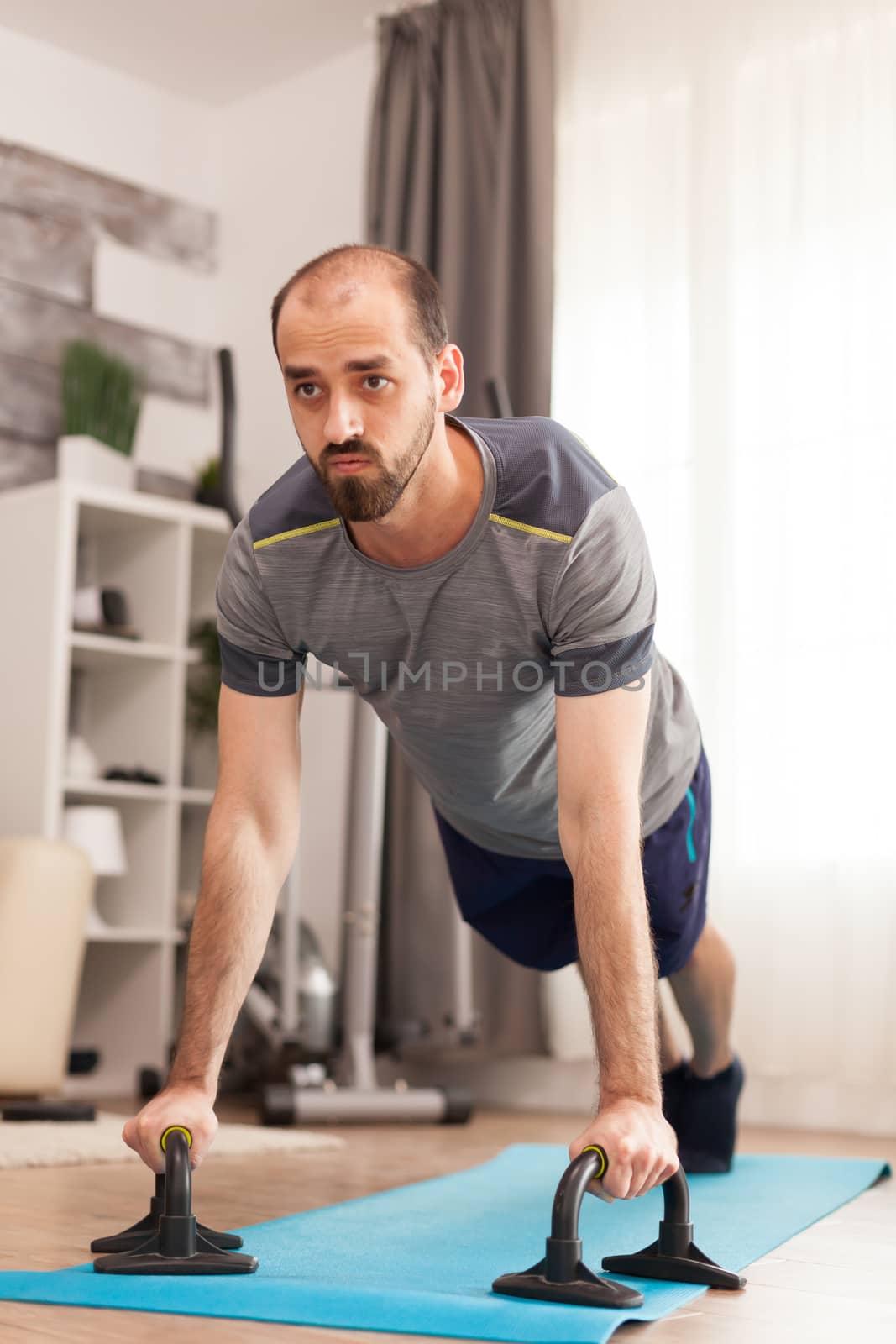 Man in good physical shape doing push ups by DCStudio