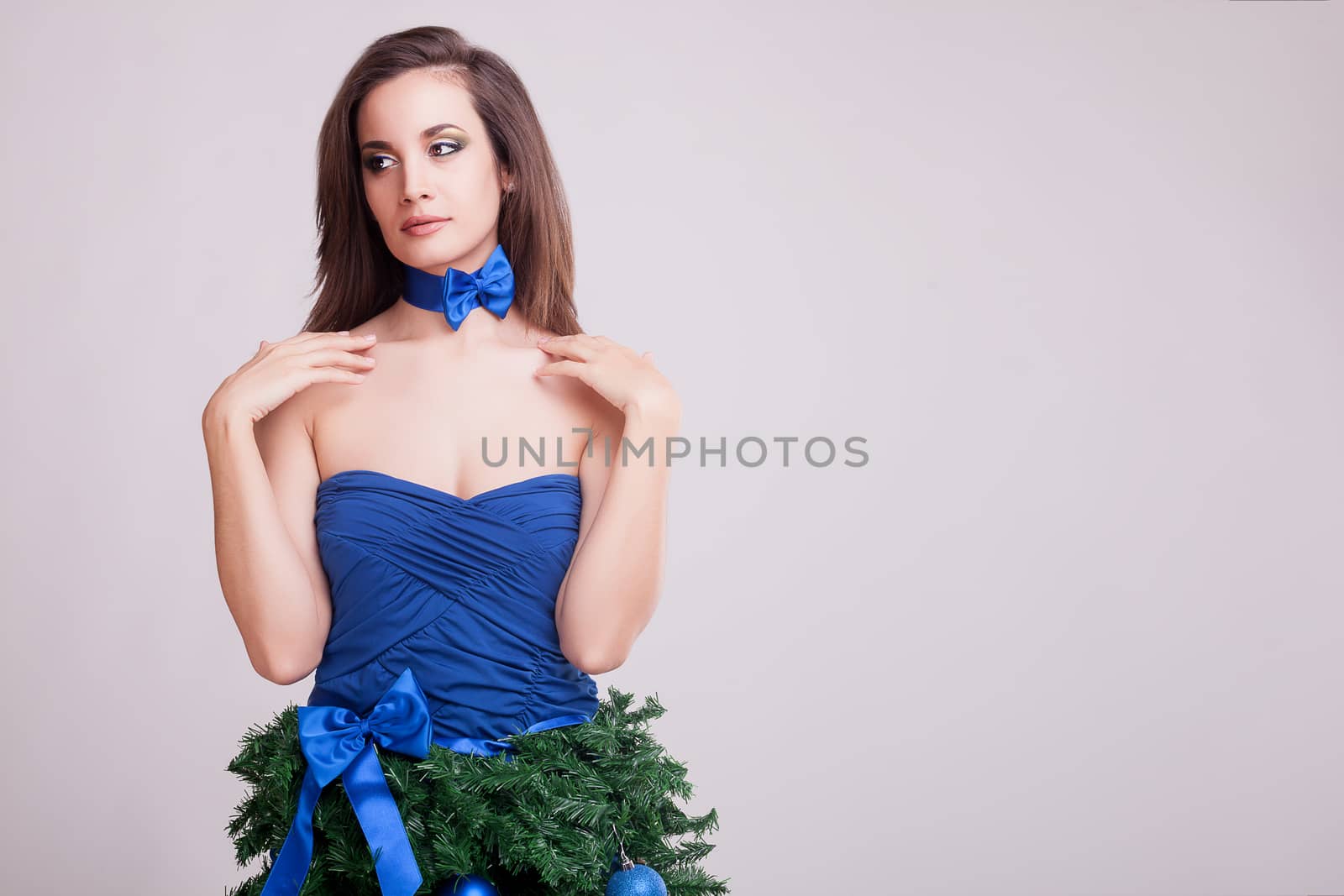 Gorgeous woman in christmas dress concept on gray background by DCStudio