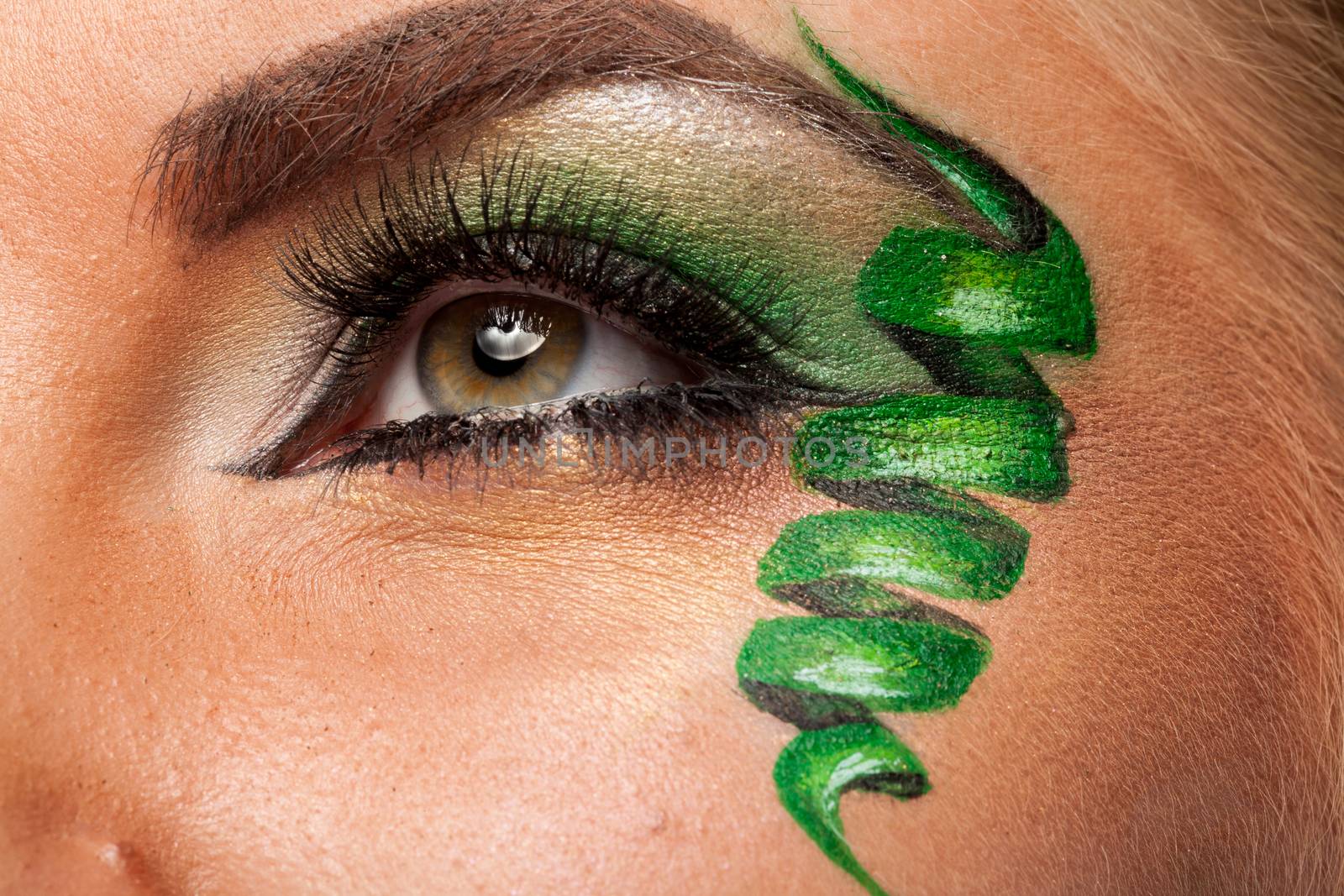 Close up of attractive eye with green artistic make up in studio photo