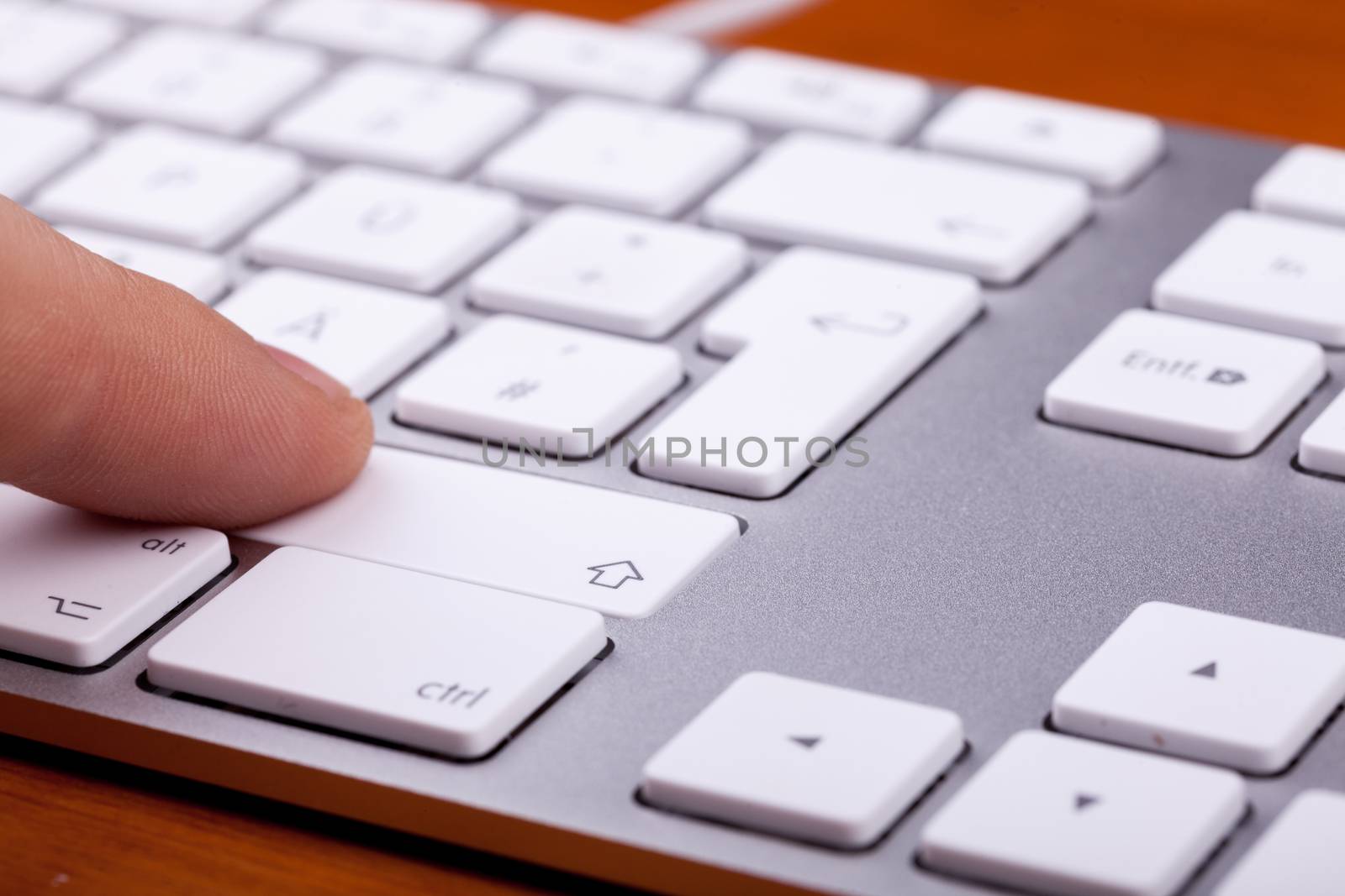 Finger pressing on keyboard key in close up