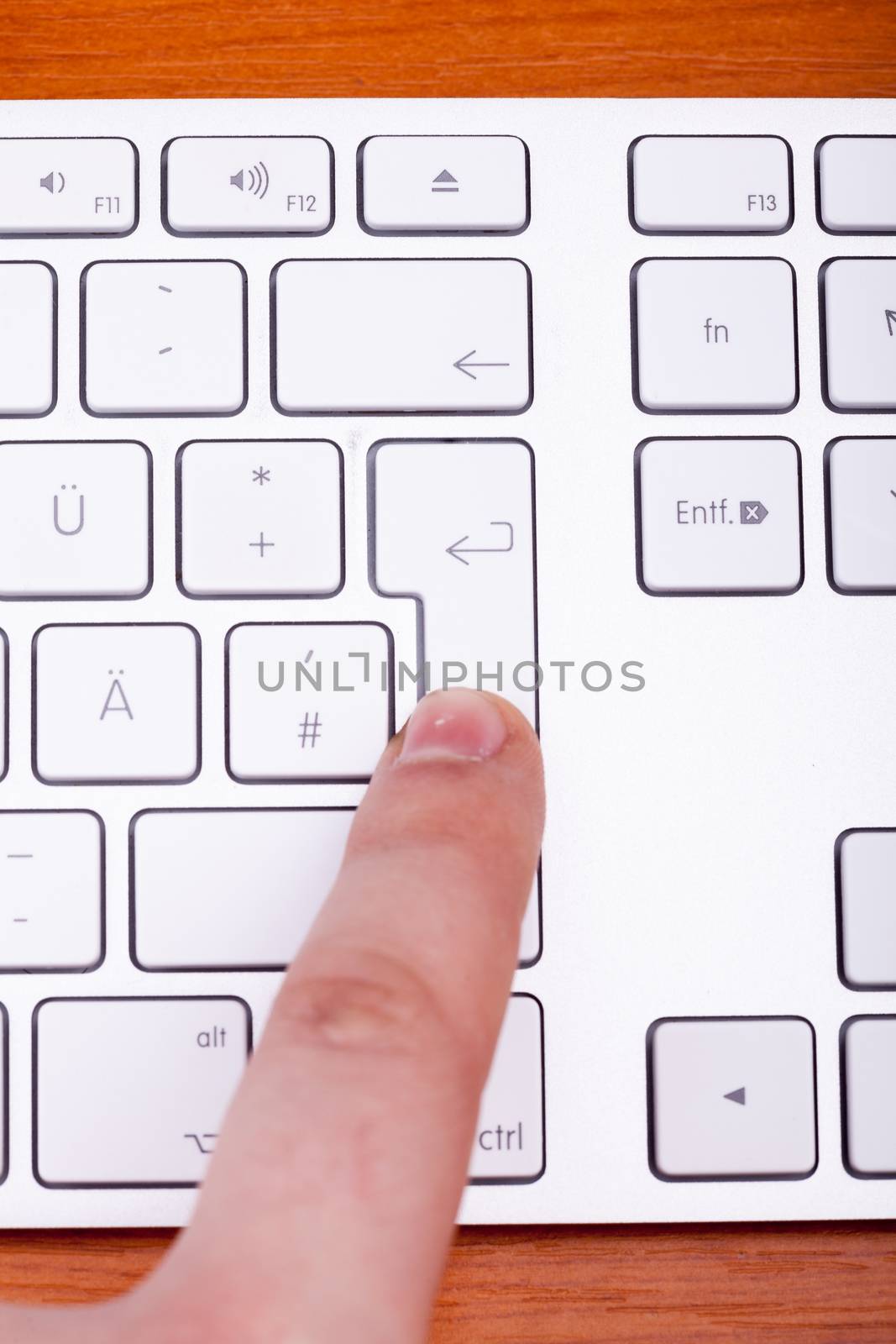 Finger pressing on keyboard key in close up