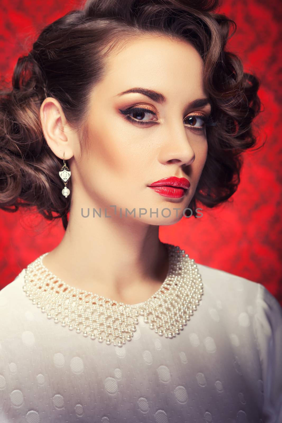 Beautiful woman toned image on vintage red background. Professional make up and hairstyle. Old-fashioned girl