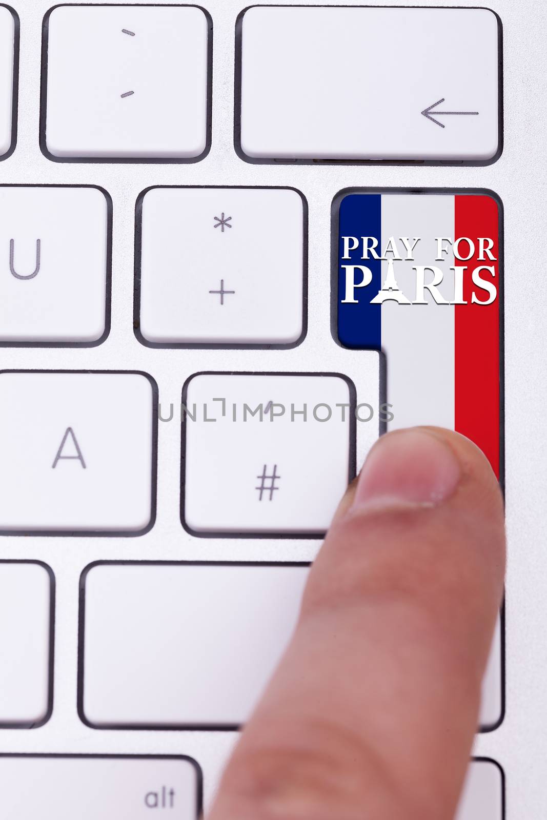 Pressing pray for Paris sign on key with France flag. Terrorist attack against France. International suport for terrorist victims in Paris atack