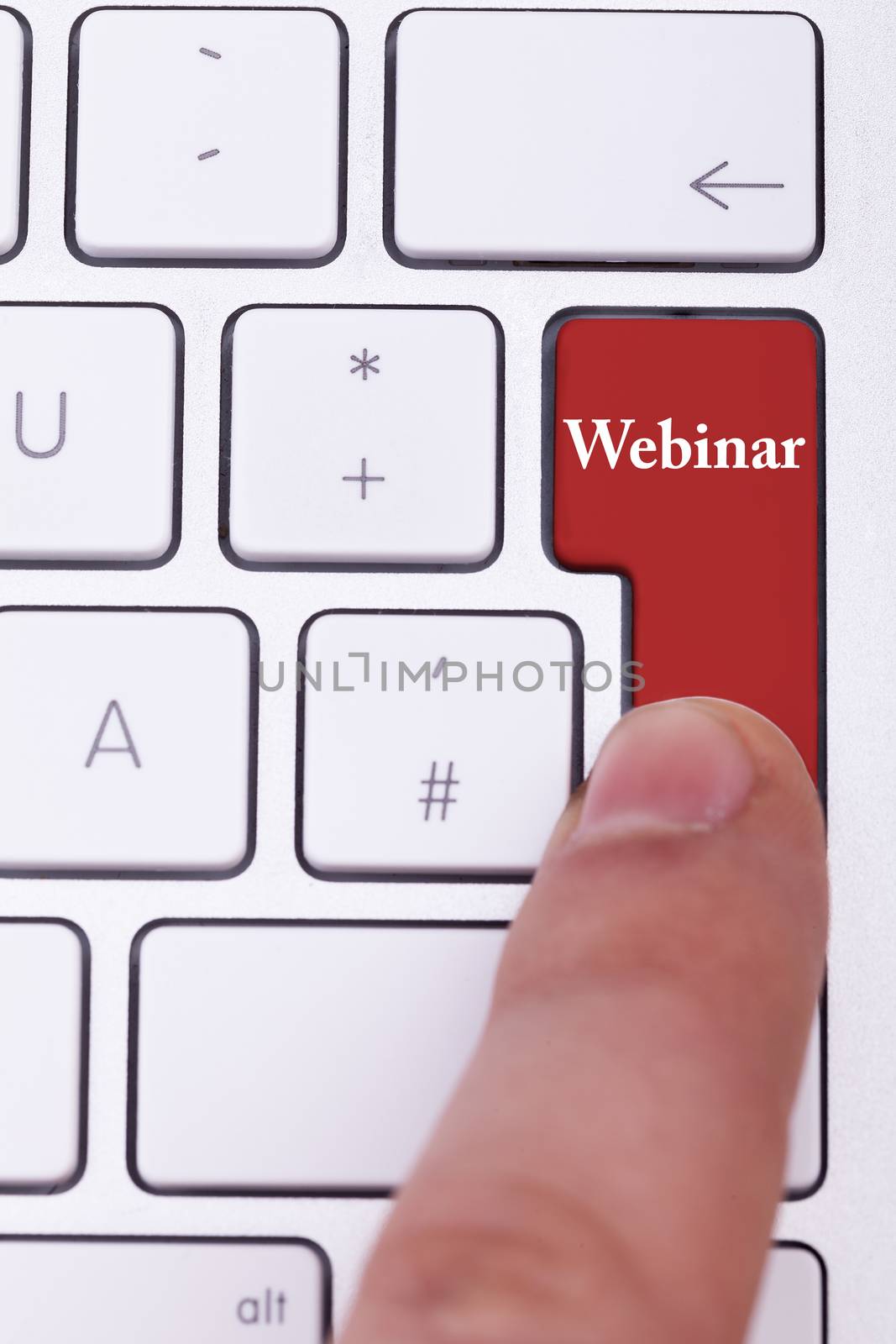 Finger pressing on red webinar button on metallic keyboard. Online learning