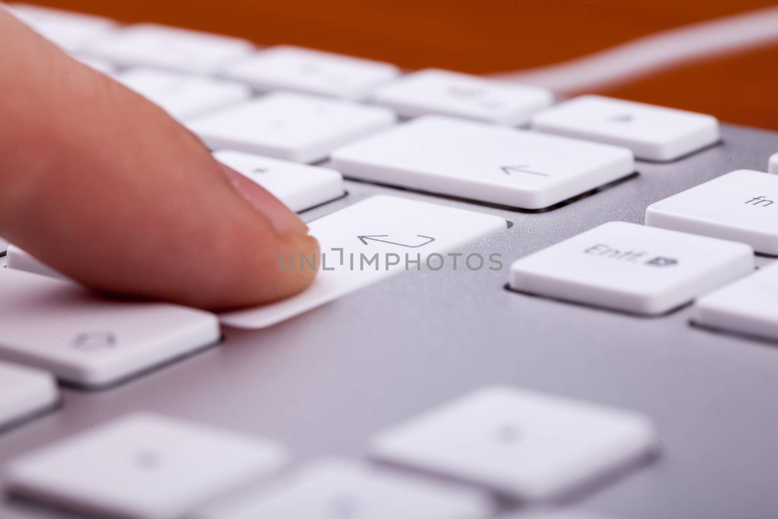 Finger pressing on keyboard key in close up