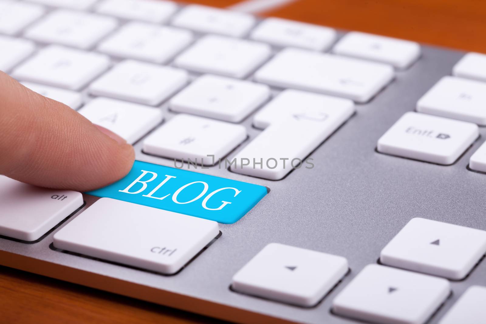 Finger pressing on blog button on keyboard. Online writing and succes