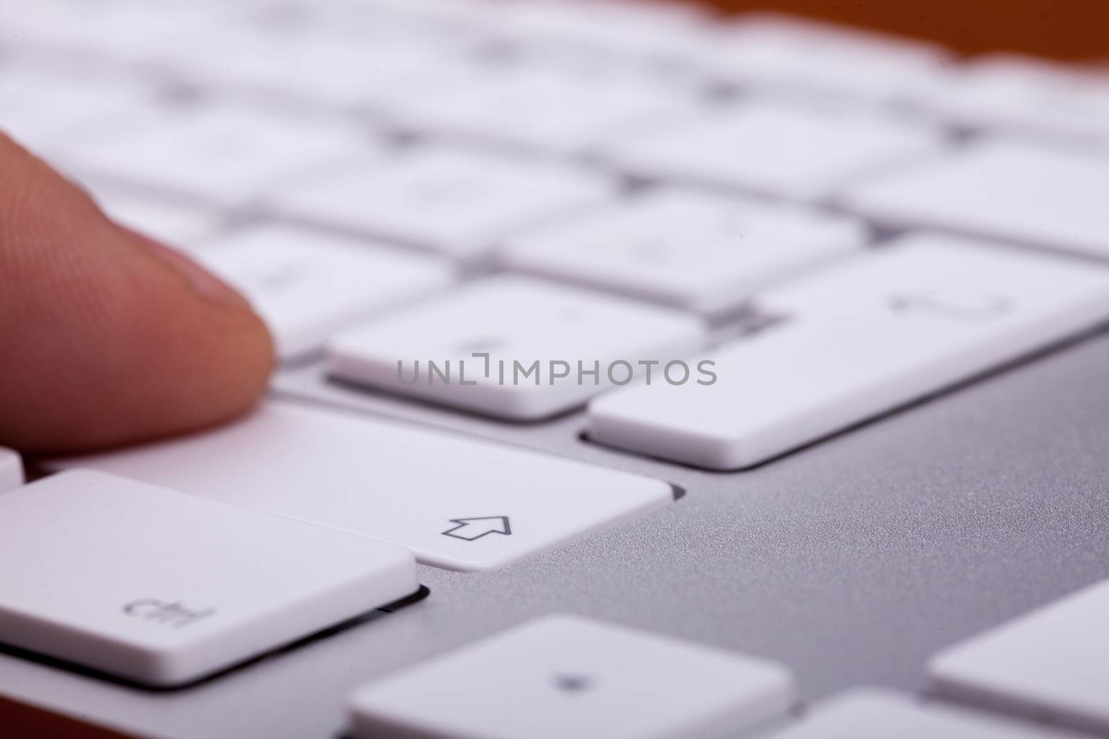 Finger pressing on keyboard key in close up