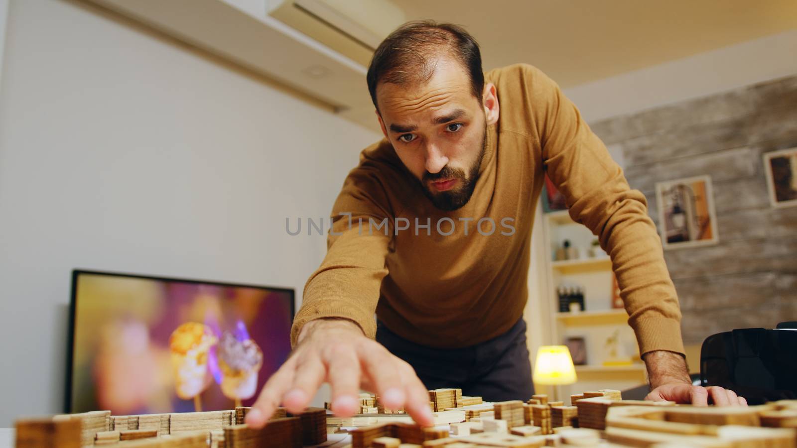 Creative architect in his home office working on a big project for the city. Building models.