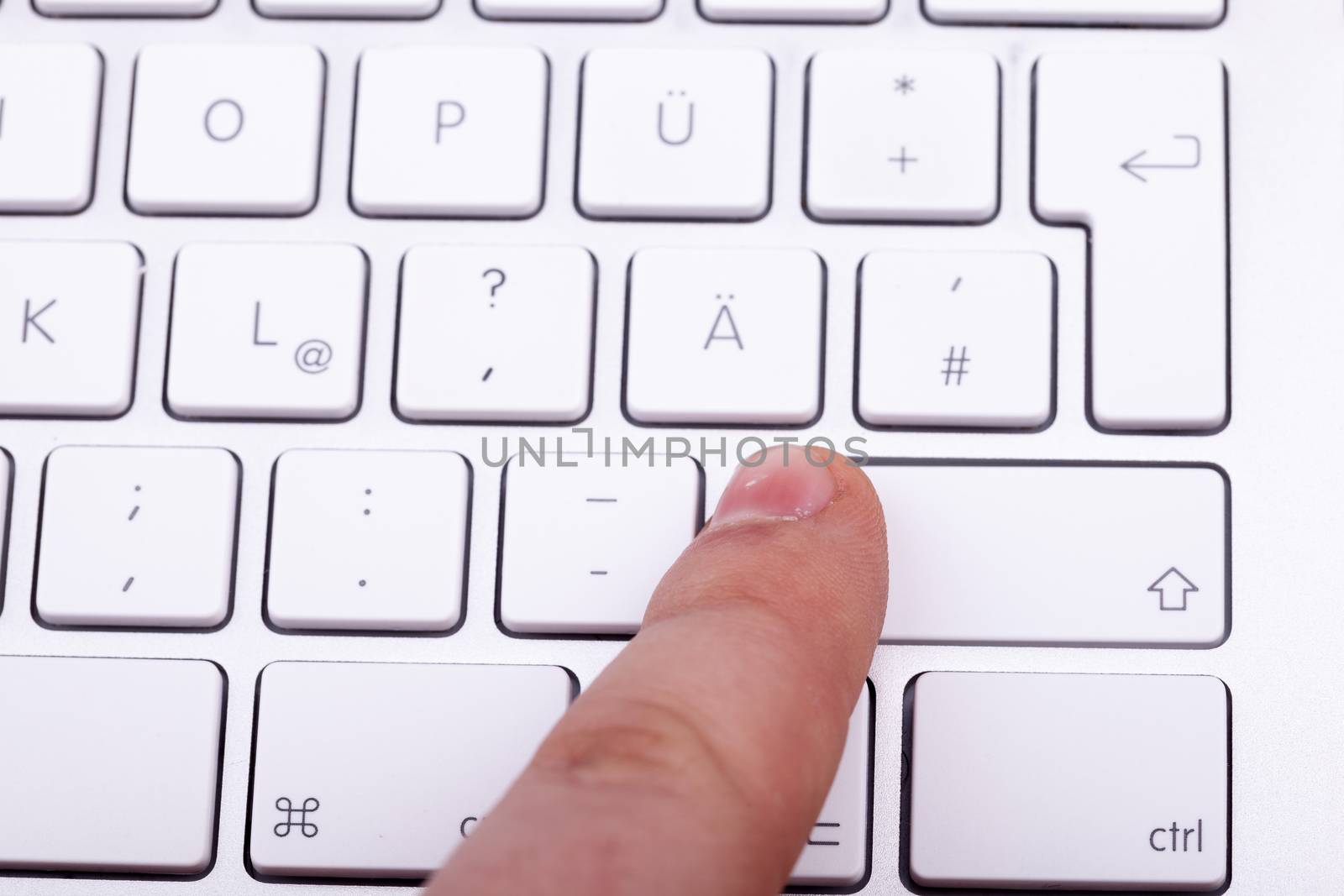 Finger pressing on keyboard key in close up