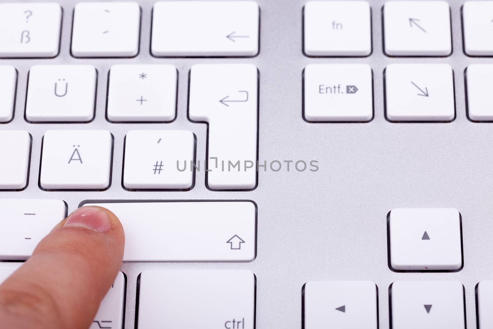 Finger pressing on keyboard key in close up