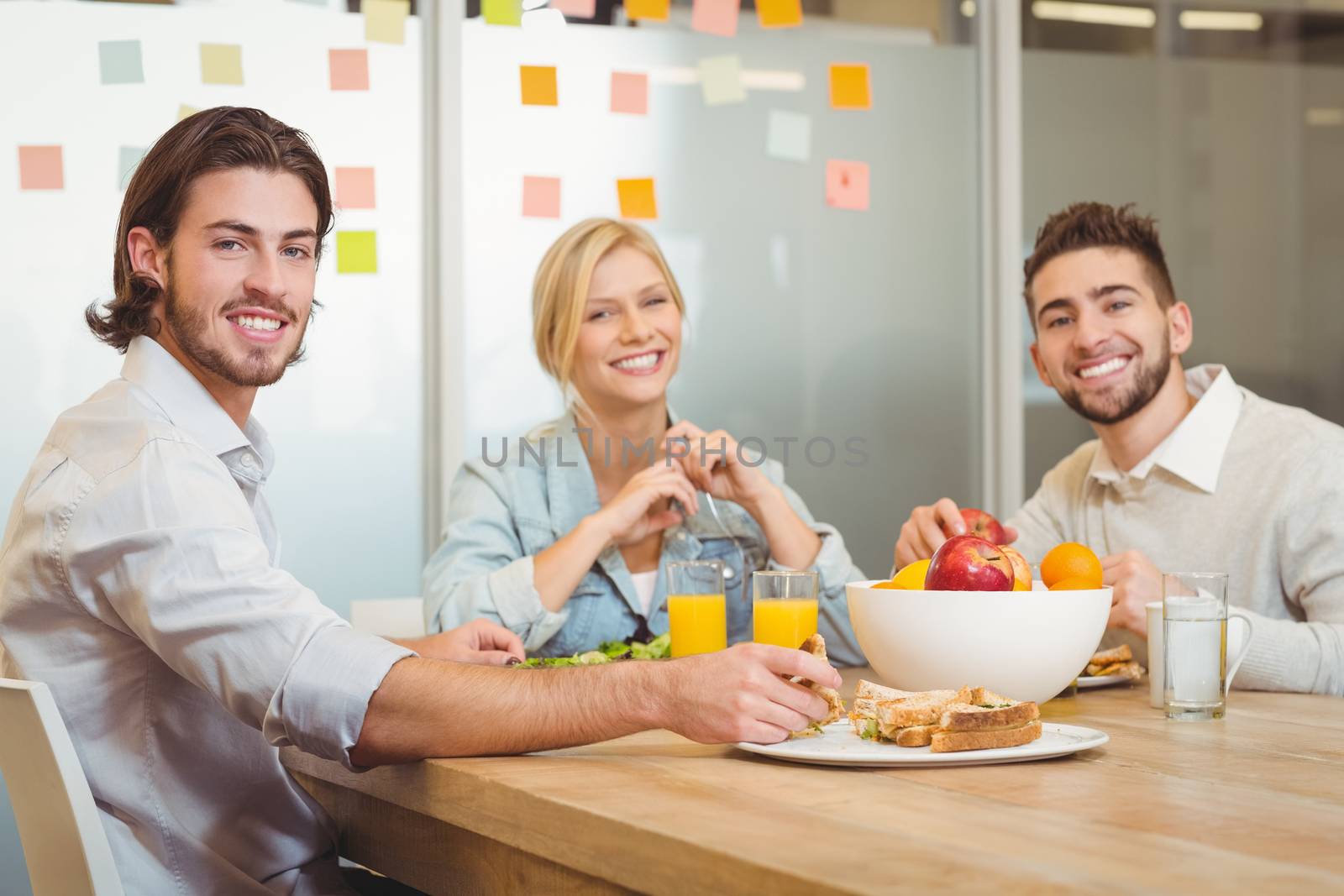 Portrait of business people having lunch in creative office