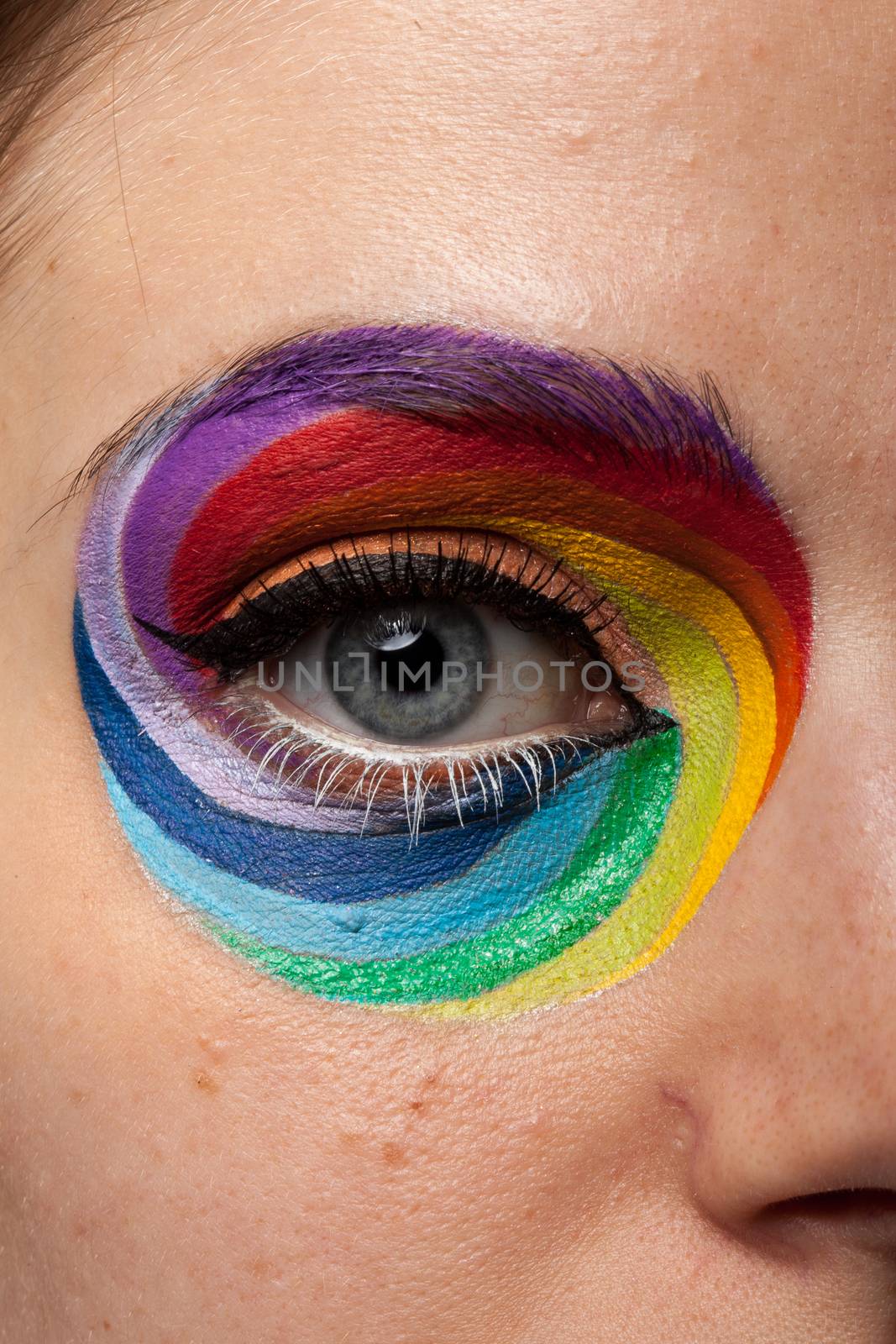 Eye in close up with artistic rainbow make up. Beauty image