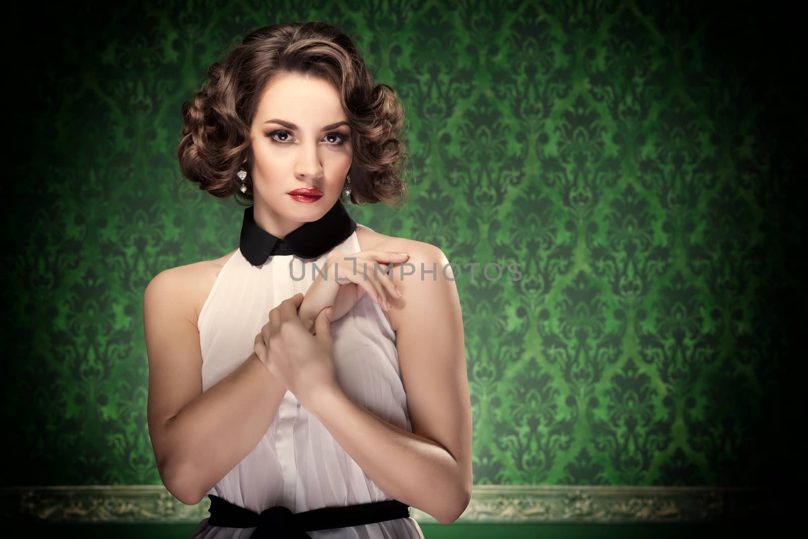 Old-fashioned woman vintage toning on retro green background. Professional make up and hairstyle. Studio lighting