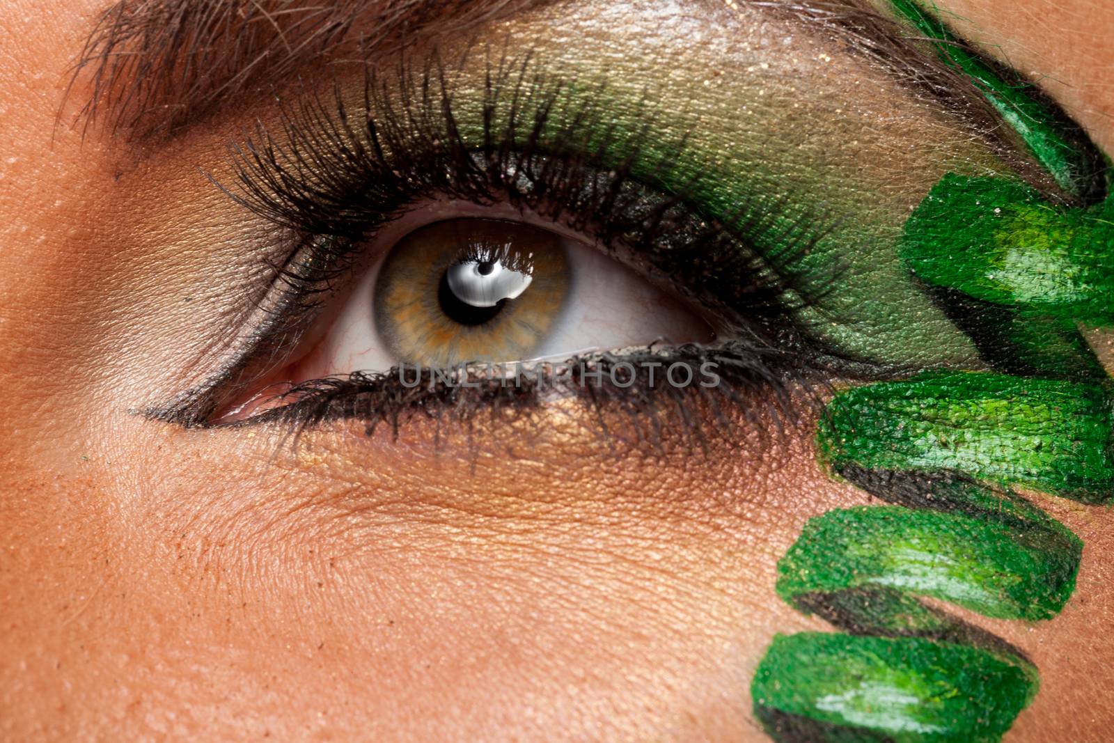 Close up of attractive eye with green artistic make up in studio photo