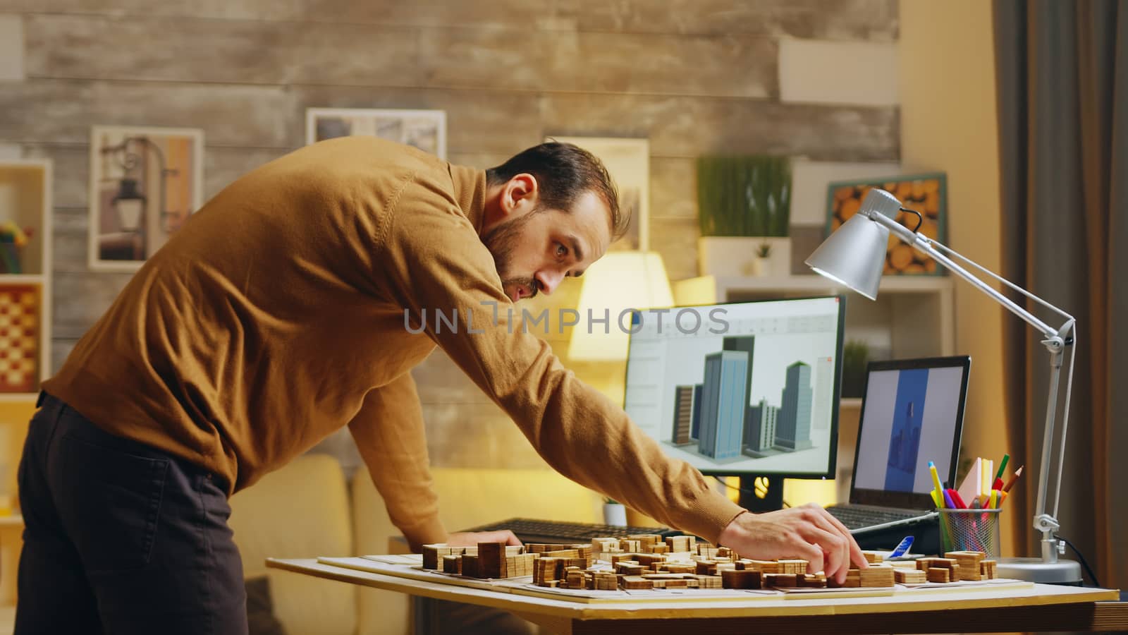 Male architect typing on computer while working on a project for the city development.