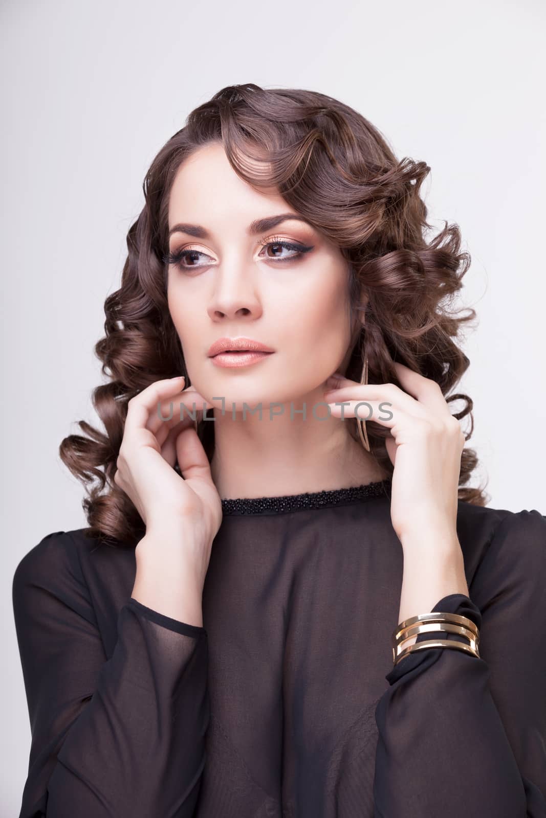 Sensual woman with hands on her neck. Professional make up and hairstyle. Studio lighting