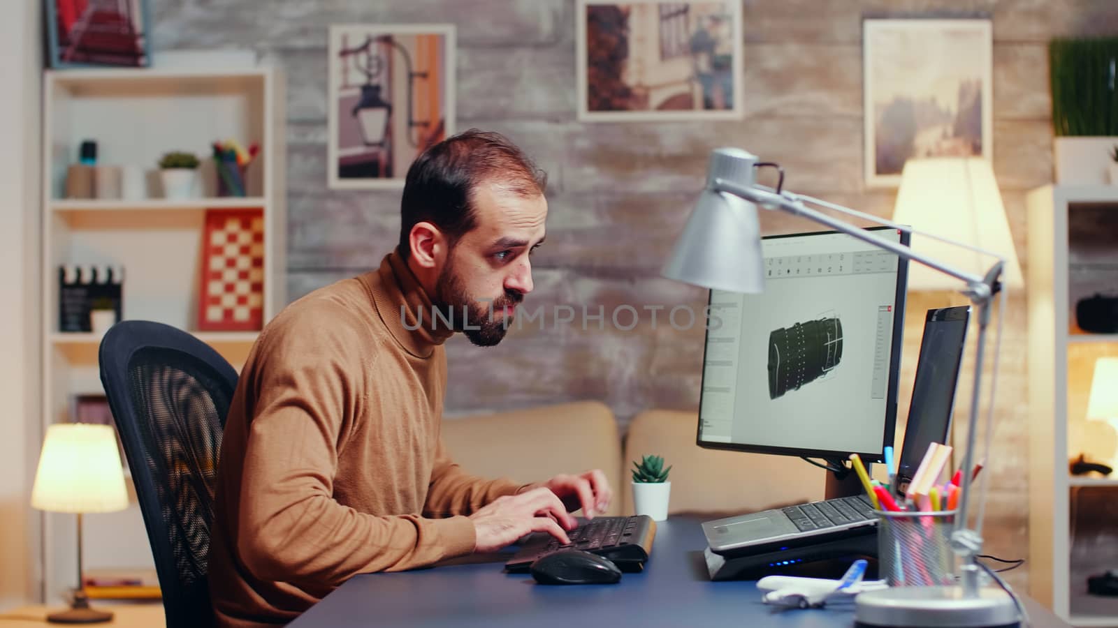 Young engineer working late at night in his home office to finish modern turbine.