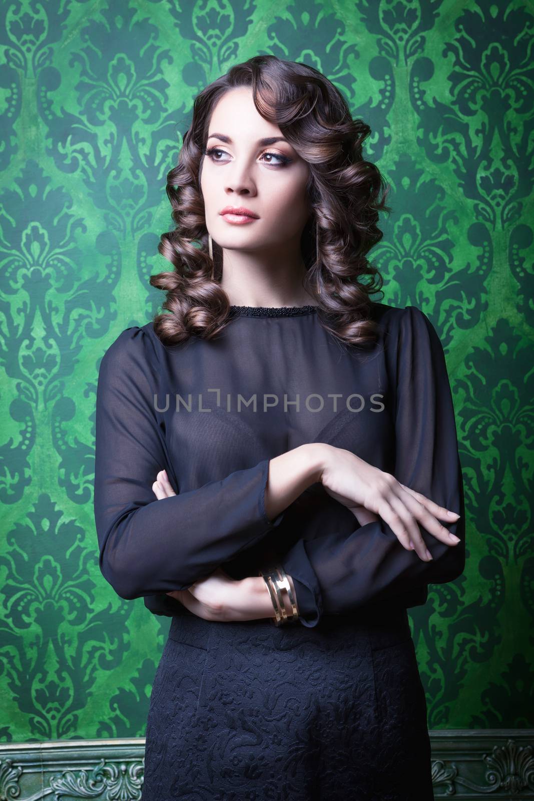 Sensual woman in green vintage interior. Professional make up and hairstyle. Studio lighting